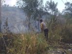 Bhabinkamtibmas Pineleng Pimpin Warga Padamkan Api di Lahan yang Terbakar